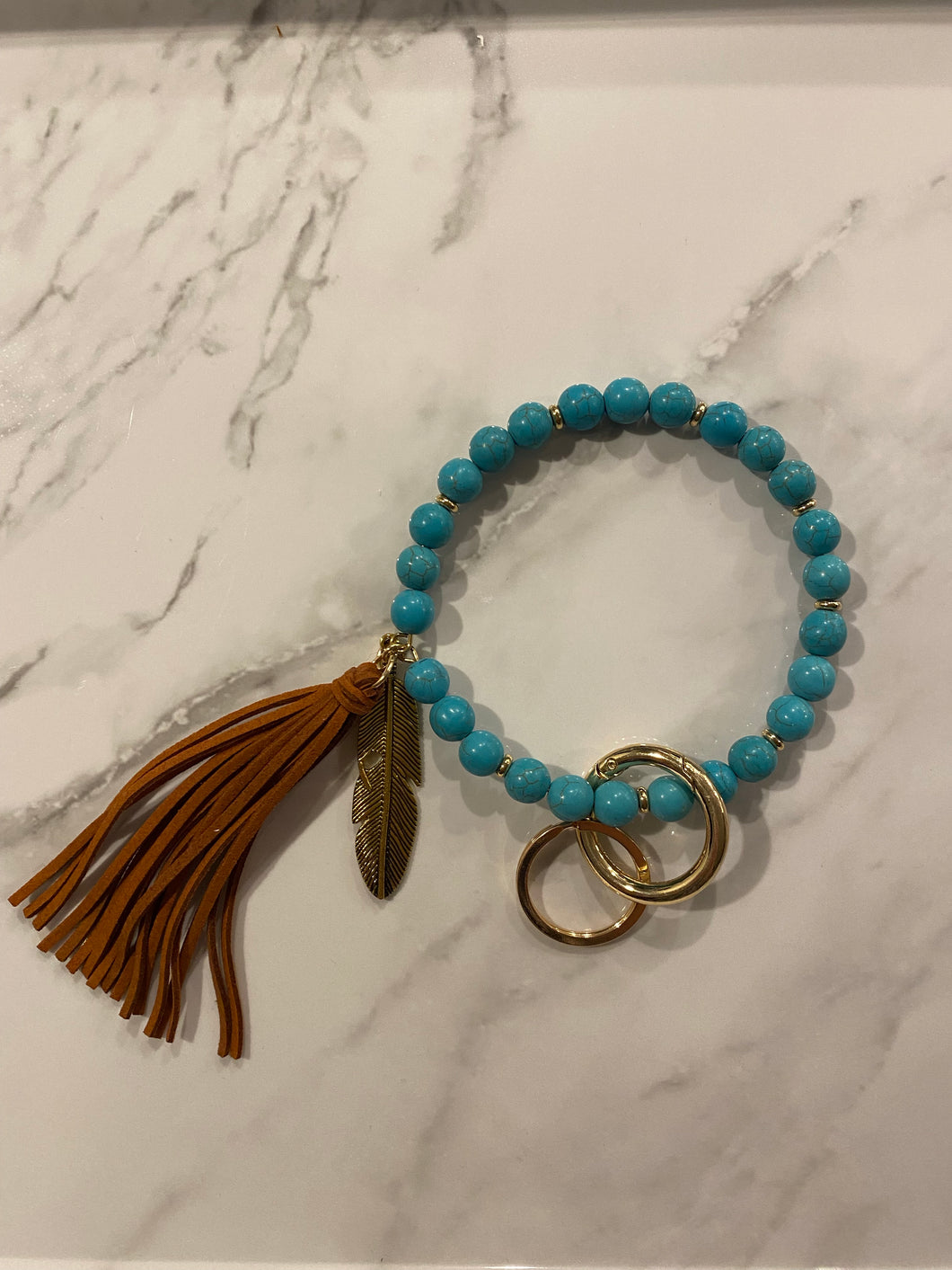Bangle with cognac tassel and feather charm